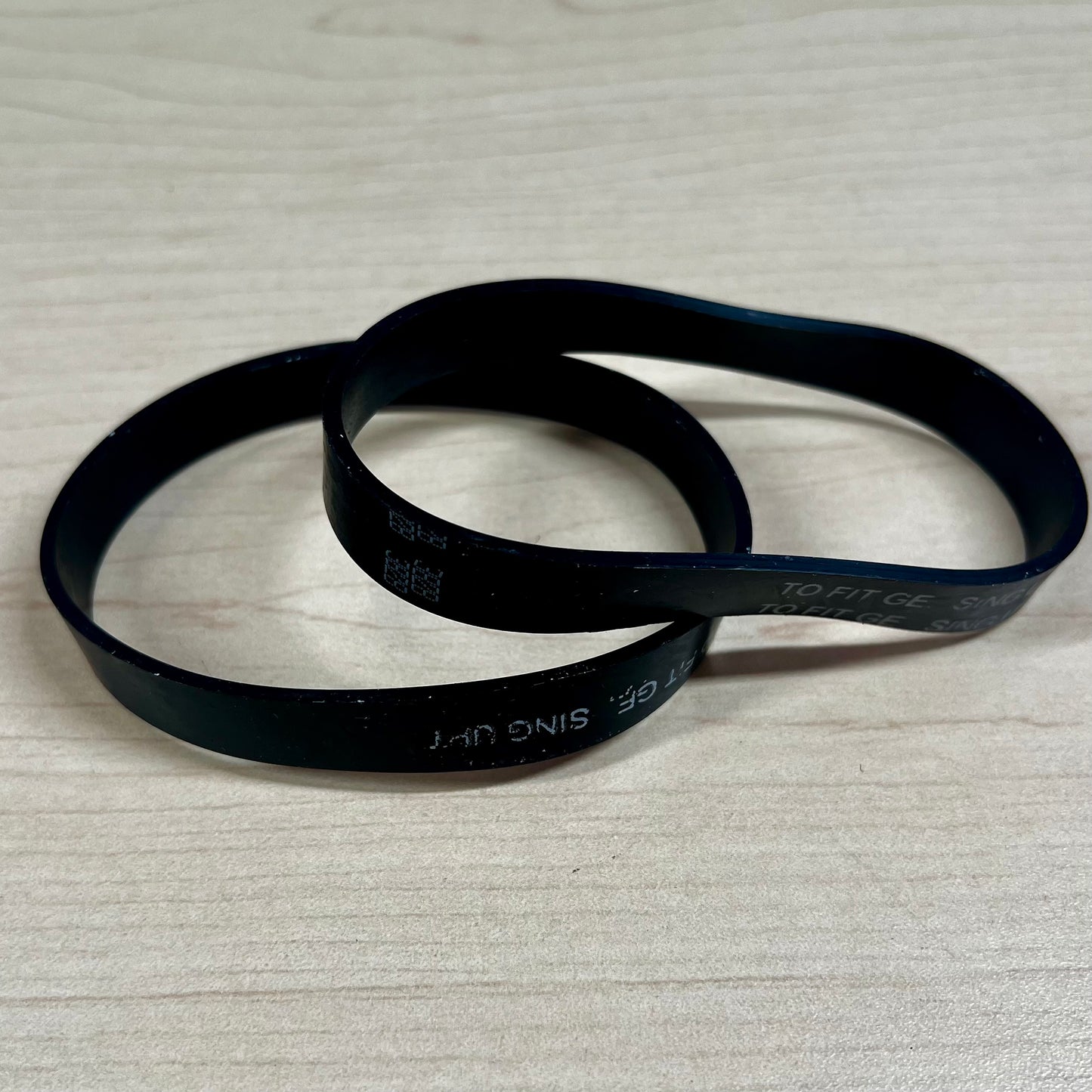 Two vacuum belts sitting on flat surface. These belts fit Riccar SupraLite, Simplicity Freedom, and Titan T500 vacuums.