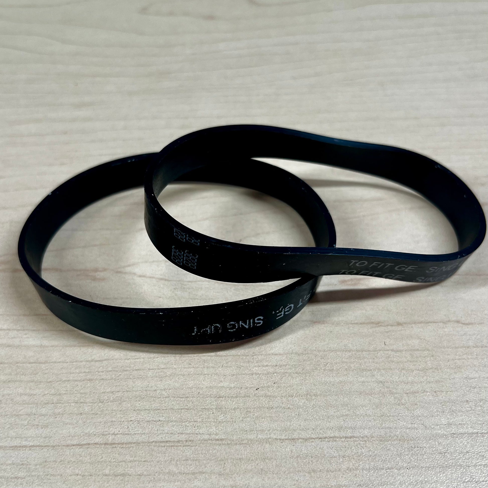 Two vacuum belts sitting on flat surface. These belts fit Riccar SupraLite, Simplicity Freedom, and Titan T500 vacuums.