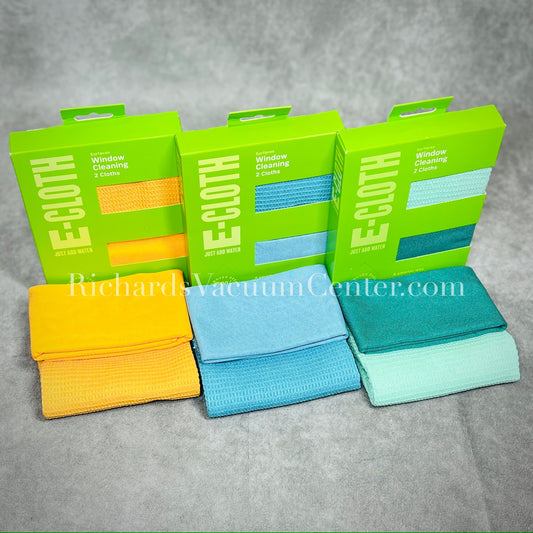 Three E-Cloth window cleaning kits with blue, green, and tangerine cloths displayed in front of their packaging boxes.
