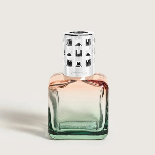 A square glass Lampe Berger bottle with a peach-to-green gradient, topped with a silver perforated cap.