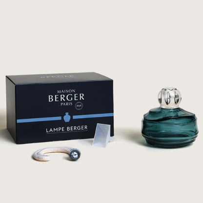 Maison Berger Paris Lampe Berger fragrance set, featuring a dark navy blue box, a translucent dark teal glass bottle with a silver cap.
