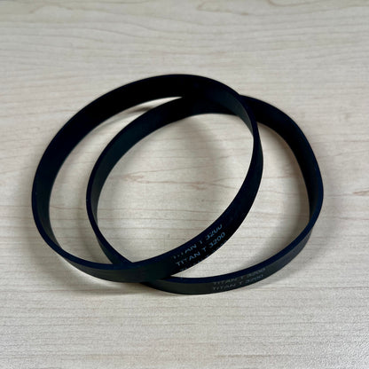 Two vacuum belts stacked on a light gray surface