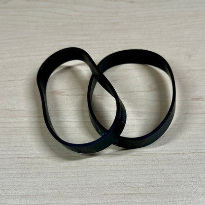 Two black vacuum belts sitting on flat surface.